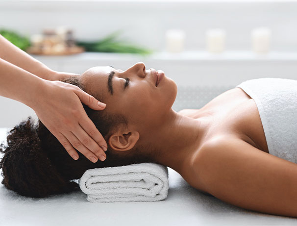 young black woman getting head massage from massage therapist